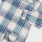 A close-up of a plaid button-up shirt with a white base and blue, teal, and thin red stripes
