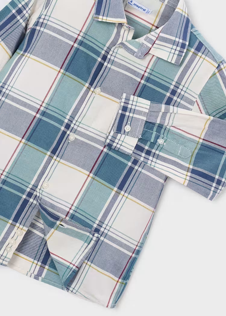 A close-up of a plaid button-up shirt with a white base and blue, teal, and thin red stripes
