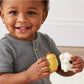 Child holding two toys, one yellow and one white, against a neutral background