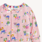 A close-up of a pink long-sleeve baby romper featuring a colorful cartoon print of cats, books, plants, and pencils, with a snap-button front and elastic collar.