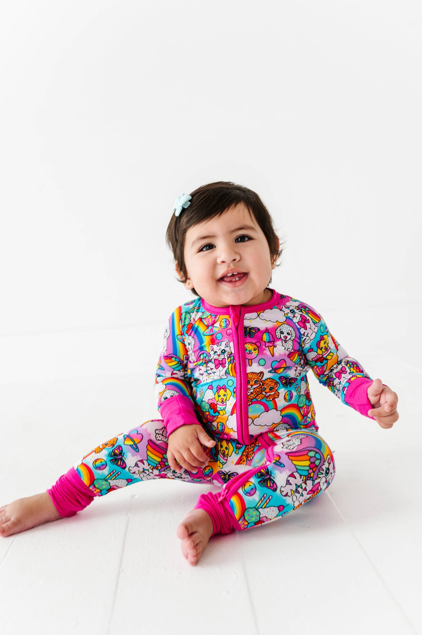 Child wearing a colorful onesie with cartoon characters on a white background