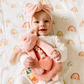 Baby holding pink bunny toy
