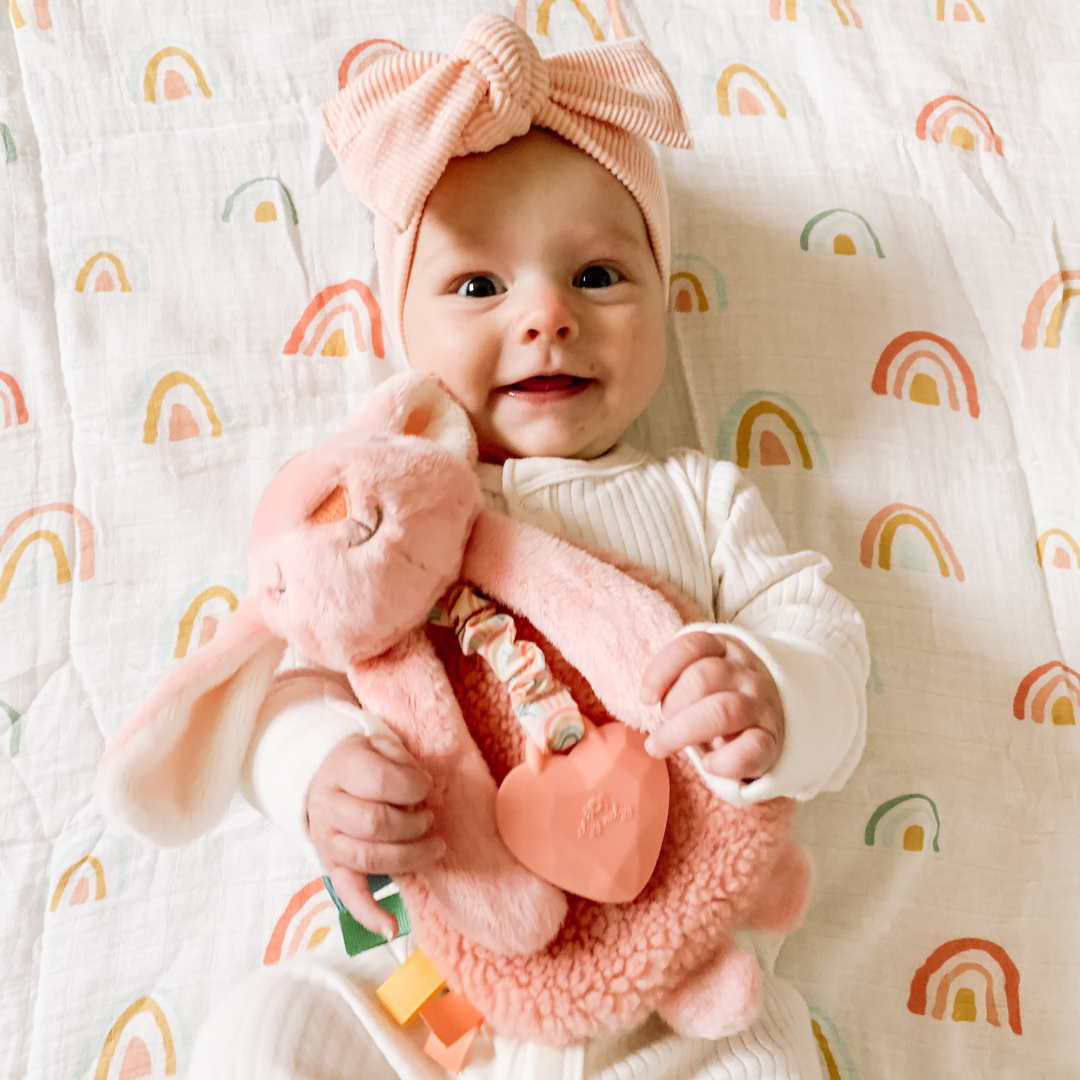 Baby holding pink bunny toy