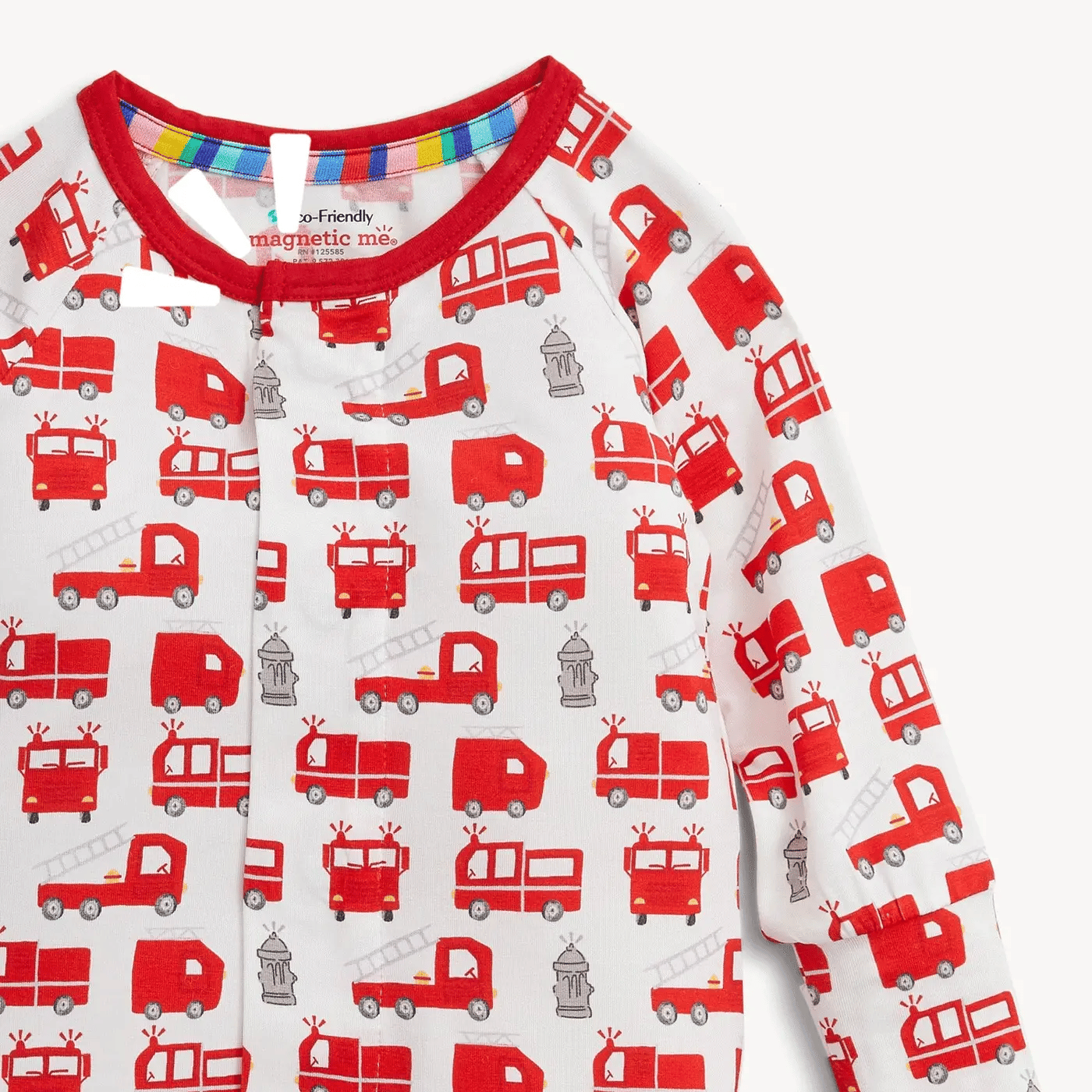 A close-up of a baby long-sleeve top with a white base and an all-over print of red fire trucks and gray fire stations, featuring a red ribbed collar.