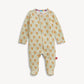 A baby footed one-piece sleeper with long sleeves and an all-over paisley pattern in orange, yellow, and green on a cream background, featuring a colorful striped inner collar.