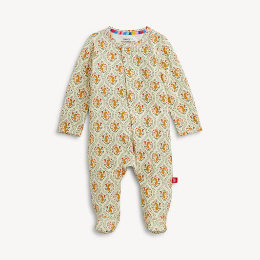 A baby footed one-piece sleeper with long sleeves and an all-over paisley pattern in orange, yellow, and green on a cream background, featuring a colorful striped inner collar.