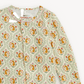 A close-up of a children's long-sleeve top by Magnetic Mom, featuring a light sage green base with a repeating pattern of orange-yellow flowers, red leaves, and small pink blossoms. The brand label 'magnetic mom' is visible inside the collar.