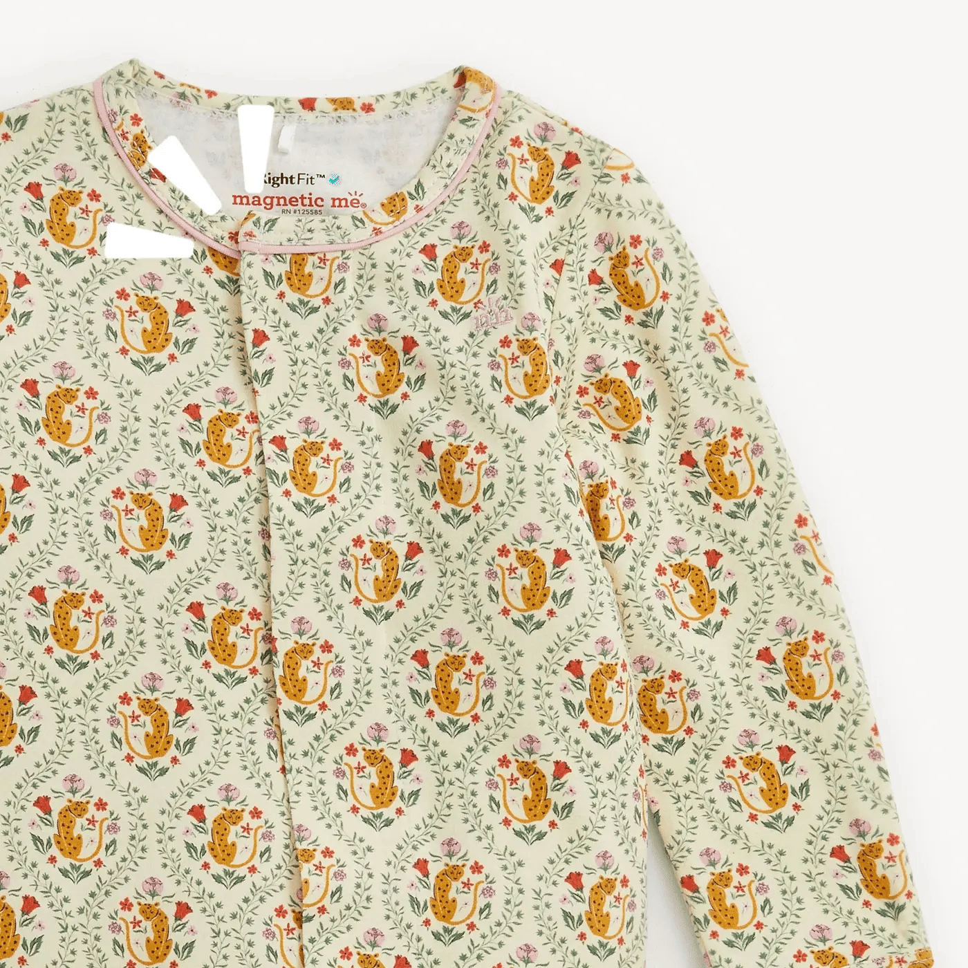 A close-up of a children's long-sleeve top by Magnetic Mom, featuring a light sage green base with a repeating pattern of orange-yellow flowers, red leaves, and small pink blossoms. The brand label 'magnetic mom' is visible inside the collar.