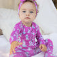 Baby wearing pink pajamas with little puppies 