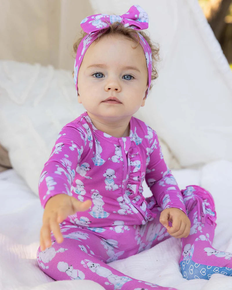 Baby wearing pink pajamas with little puppies 