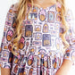 Child wearing a Halloween-themed dress with pumpkins and ghosts on a white background