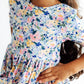 Child wearing a floral dress with a white background