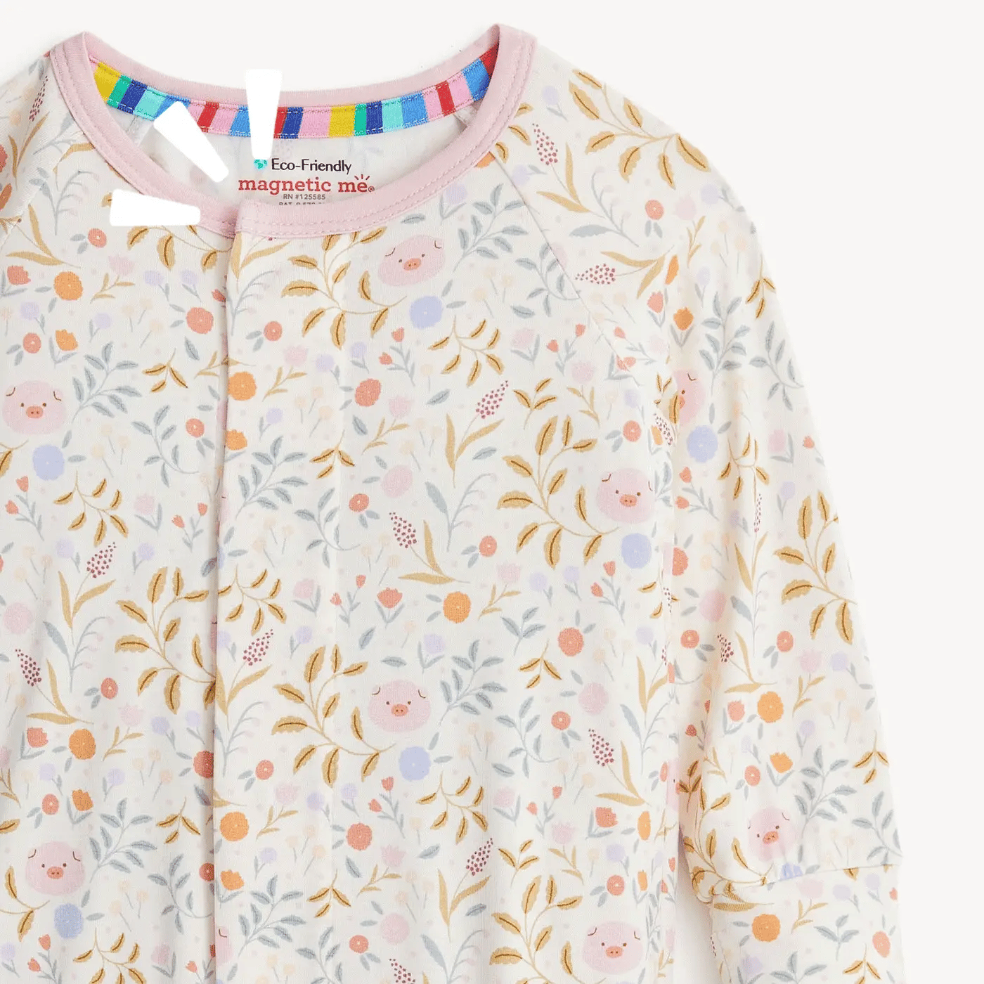 A close-up of a baby long-sleeve top with a colorful pastel floral and leaf print featuring small smiling faces. The garment has a pink collar and a magnetic snap closure at the neckline.
