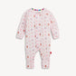A baby long-sleeve footless one-piece jumpsuit in light pink, featuring a playful pattern of teddy bears, snowmen, and snow globes in various colors, displayed against a clean off-white background.