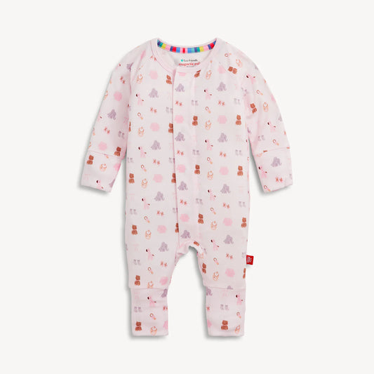 A baby long-sleeve footless one-piece jumpsuit in light pink, featuring a playful pattern of teddy bears, snowmen, and snow globes in various colors, displayed against a clean off-white background.