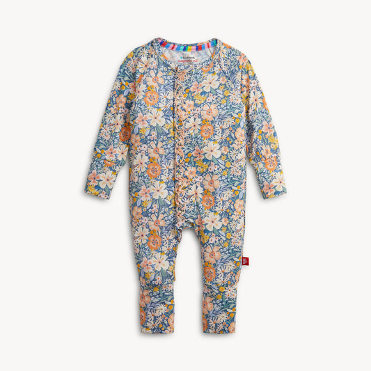 A baby long-sleeve footless one-piece romper with an all-over floral print in blue, pink, orange, and cream, featuring a snap-button front closure and a small red tag on the leg.